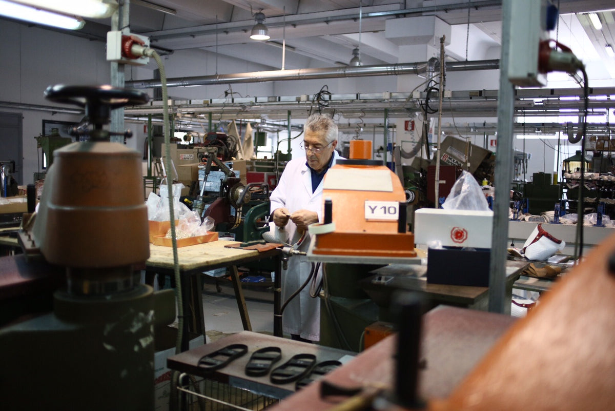 A Galiano artisan hand-finishing a shoe